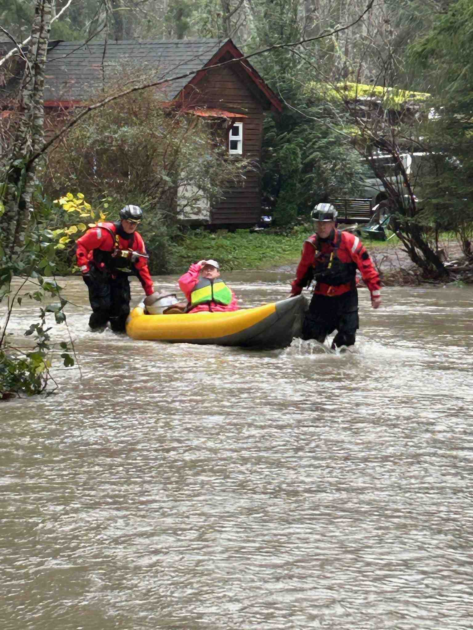 Flood rescue on flooded street with rescue team evacuating a resident in a small boat