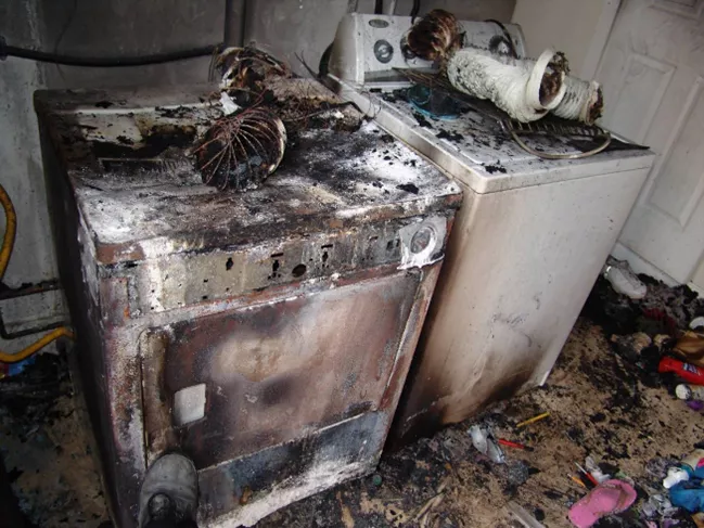 Tumble dryer with flames illustrating fire risk
