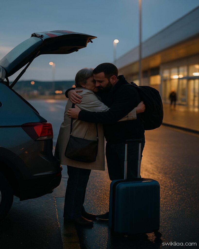 A quiet airport drop-off moment as a parent and adult child share an emotional goodbye before a flight in the UK.