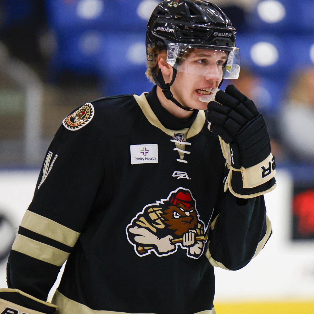 A young ice hockey center skating during a game as NHL Draft attention grows around his midseason move to Boston University