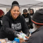 Shirley Raines, founder of Beauty 2 The Streetz, distributes hygiene supplies to a person experiencing homelessness during a community outreach event in Los Angeles.