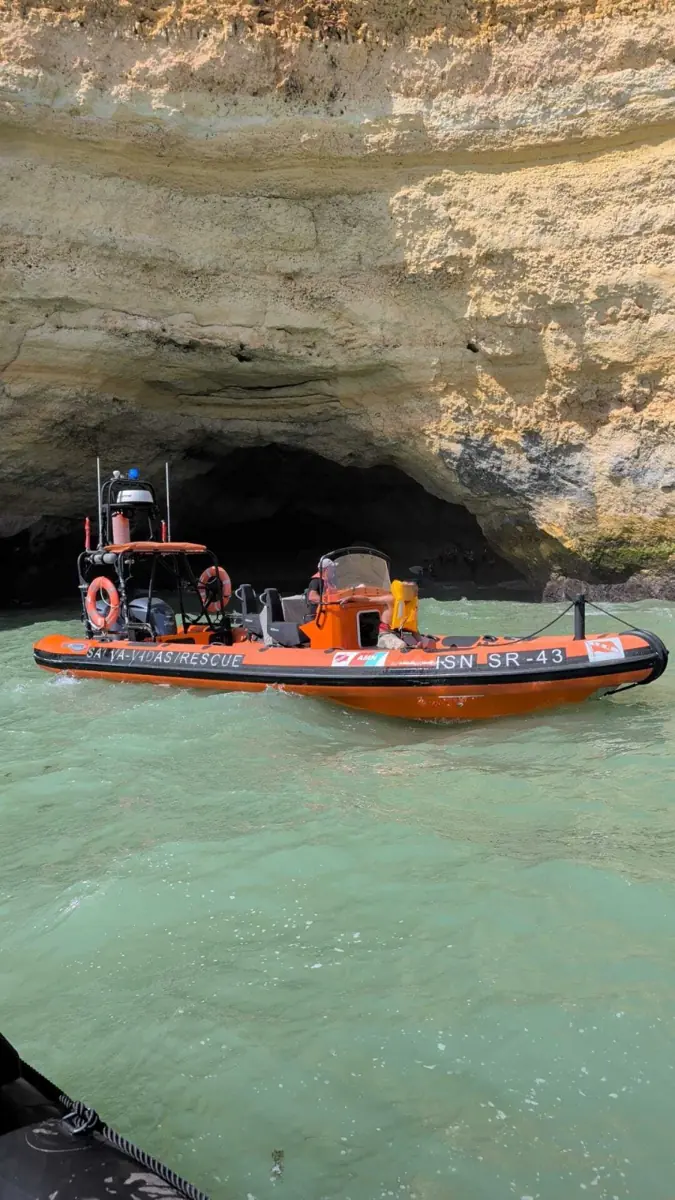 Rescue boat near sea cave on turquoise water