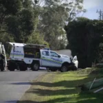 Police and emergency vehicles respond to a serious single-vehicle crash on Burwood Drive in Blackmans Bay, Tasmania, where two people were hospitalized and power lines were damaged, leaving more than 300 customers without electricity