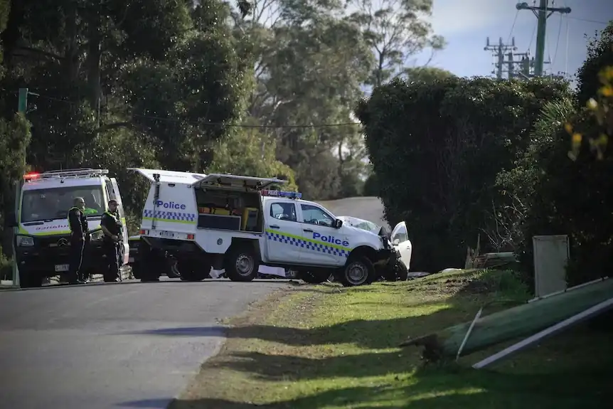 Police and emergency vehicles respond to a serious single-vehicle crash on Burwood Drive in Blackmans Bay, Tasmania, where two people were hospitalized and power lines were damaged, leaving more than 300 customers without electricity