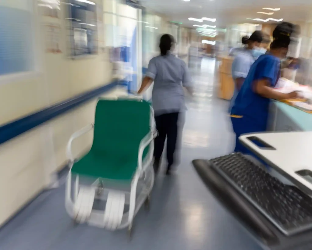 England hospital corridor during heatwave as NHS staff respond to rising patient demand amid equipment and cooling system disruptions