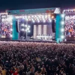 Crowds gather in front of the illuminated main stage during Lytham Festival 2026 at Lytham Green as thousands of music fans attend the five-day outdoor music festival in Lancashire, England.