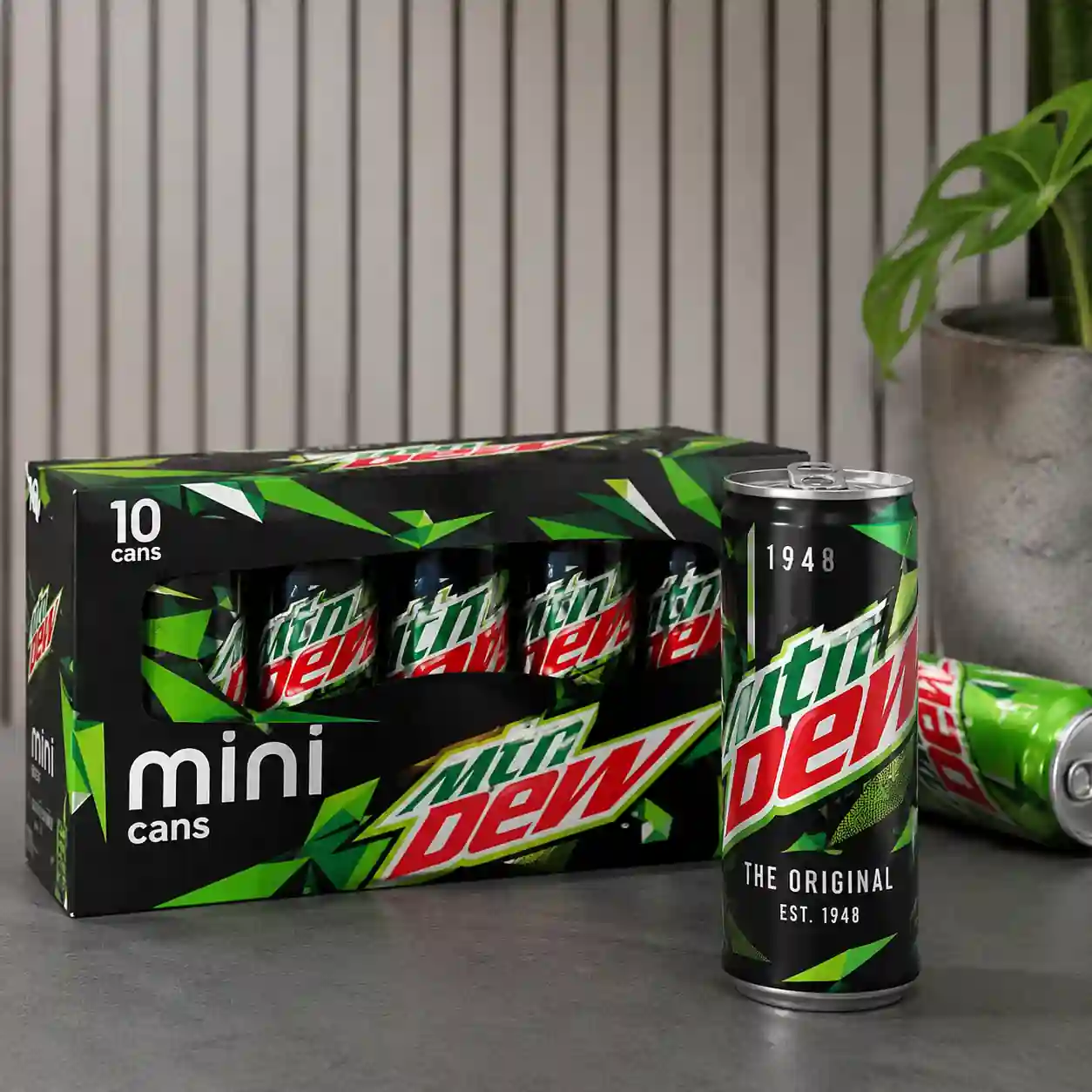 Limited-edition Mountain Dew commemorative can displayed beside a 10-pack of Mountain Dew Mini cans, highlighting the brand's 1948 anniversary collectible bundle in a clean editorial product shot.