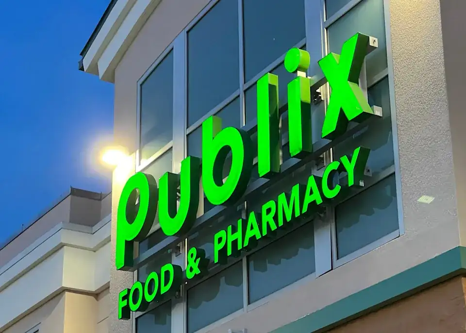 Publix Food & Pharmacy storefront exterior with illuminated green Publix signage on a modern grocery store building in Florida.