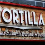 Tortilla Mexican Grill storefront sign displayed on a wooden exterior facade with the slogan "Real California Burritos & Tacos," representing the restaurant chain amid news of its AIM share suspension following a £2.5 million accounting error