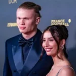 Erling Haaland and his girlfriend Isabel Haugseng Johansen pose together at a football awards ceremony, both wearing formal evening attire.