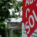 Australian property auction sold sign outside a residential home as auction clearance rates remain below 50% amid housing market slowdown