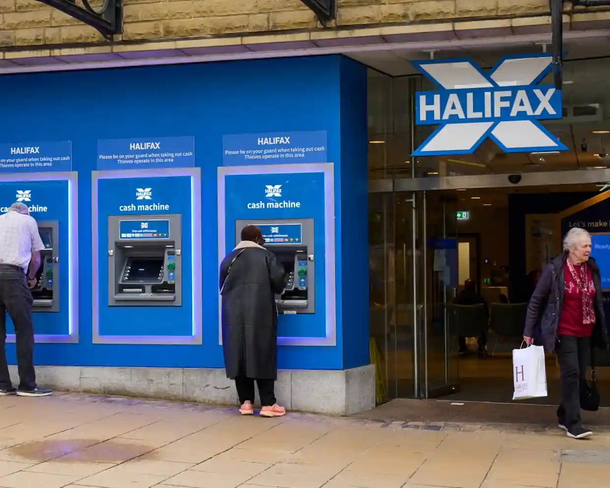 Halifax bank branch with customers using cash machines before Lloyds Banking Group's planned rebranding of the 173-year-old Halifax brand.