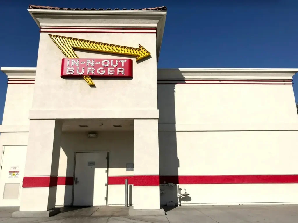 In-N-Out Burger restaurant exterior with the chain's iconic yellow arrow logo as the company announces six new restaurant locations across five U.S. states.