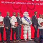 "Chefs and hospitality leaders stand on stage during the Michelin Guide New Zealand 2026 awards ceremony in Auckland, celebrating the country's first Michelin-starred restaurants."