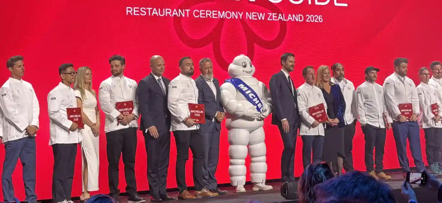 "Chefs and hospitality leaders stand on stage during the Michelin Guide New Zealand 2026 awards ceremony in Auckland, celebrating the country's first Michelin-starred restaurants."