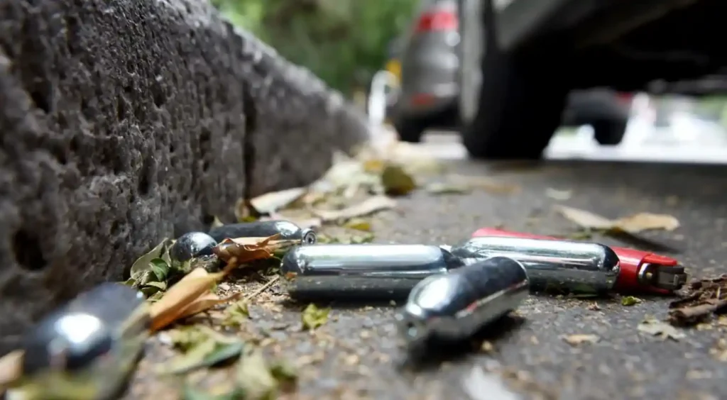 Discarded nitrous oxide (nangs) canisters on a roadside in New South Wales as Australia introduces stricter retail sales rules and age restrictions.