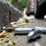 Discarded nitrous oxide (nangs) canisters on a roadside in New South Wales as Australia introduces stricter retail sales rules and age restrictions.