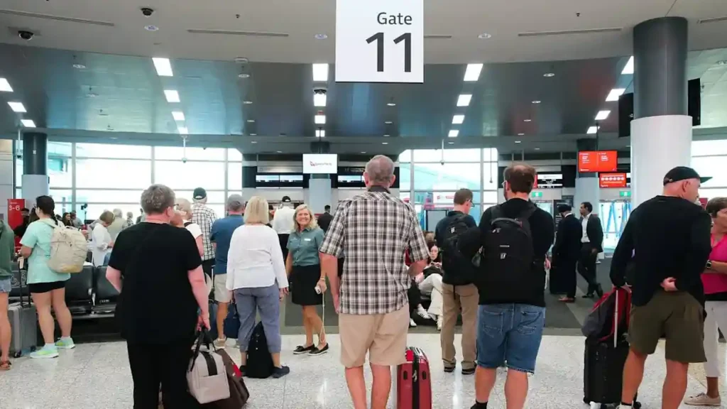 Passengers wait at a Qantas airport gate as customers check eligibility for the $105 million class action settlement over COVID-era flight credits.