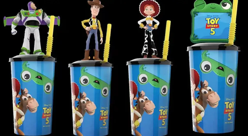 Toy Story-inspired collectible cups with decorative toppers displayed in a cinema, illustrating a product recall over a potential choking hazard.