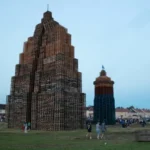 Traditional Twelfth of July bonfires built from wooden pallets before Orange Order celebrations in Northern Ireland, with crowds gathered around the structures at dusk.