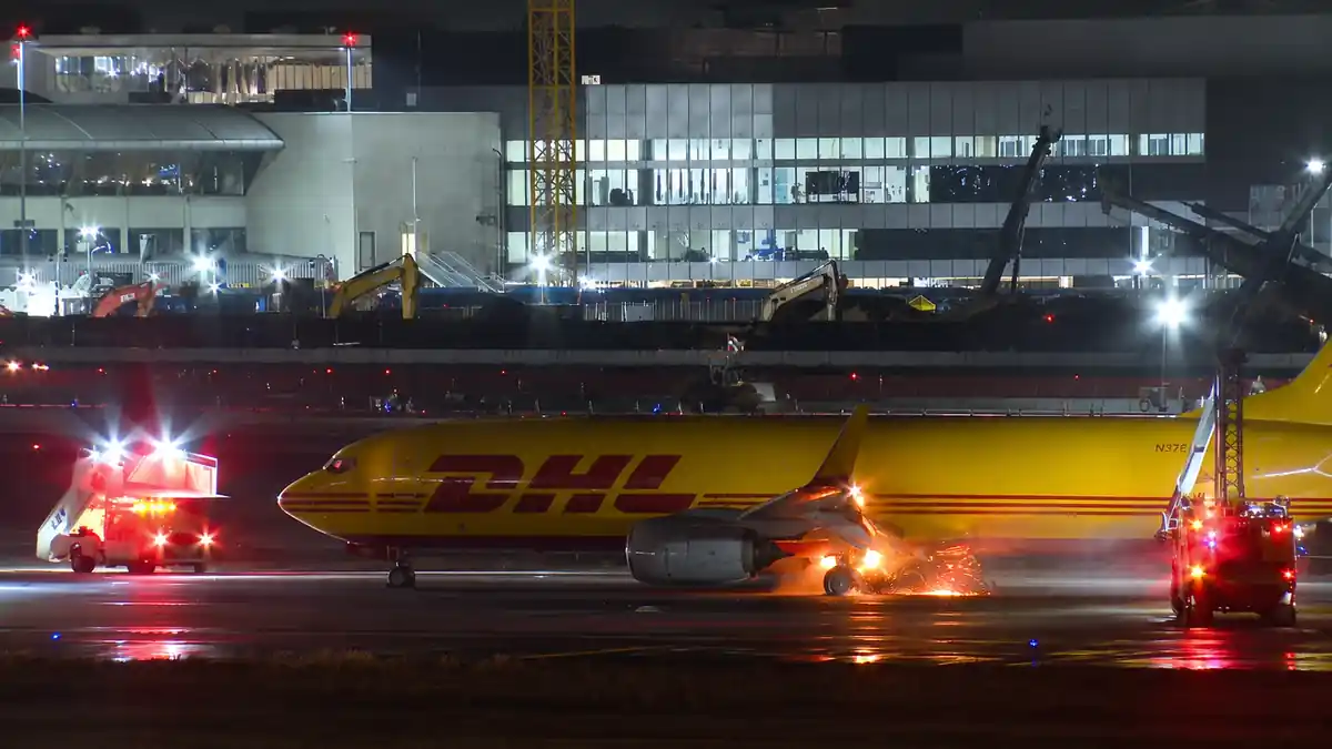 DHL cargo plane with flames near rear landing gear during landing at LAX
