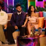 Love Island USA Season 8 cast members seated together on a colorful reunion studio set