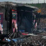 Luke Combs performing at a packed stadium concert