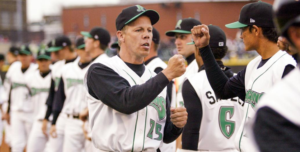Dayton Dragons manager Todd Benzinger exchanges fist bumps with players before the 2009 season opener.