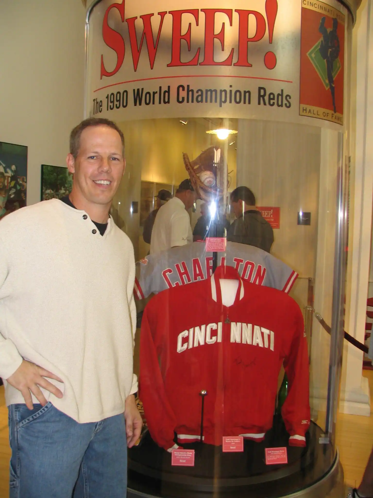 Todd Benzinger beside a display celebrating the Cincinnati Reds’ 1990 World Series championship.
