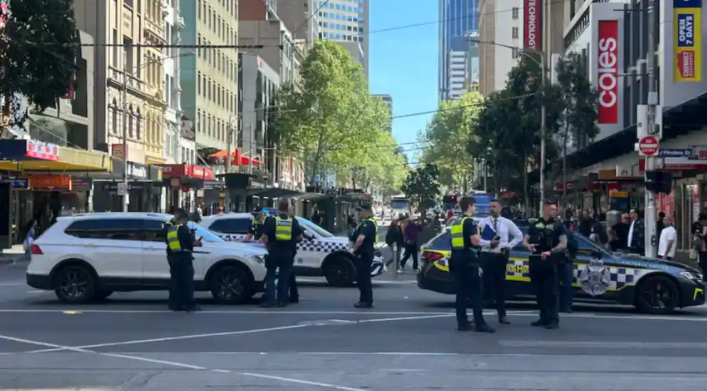 Police and emergency vehicles near Flinders Street Station in Melbourne following reports of a car striking a woman close to the marathon route.